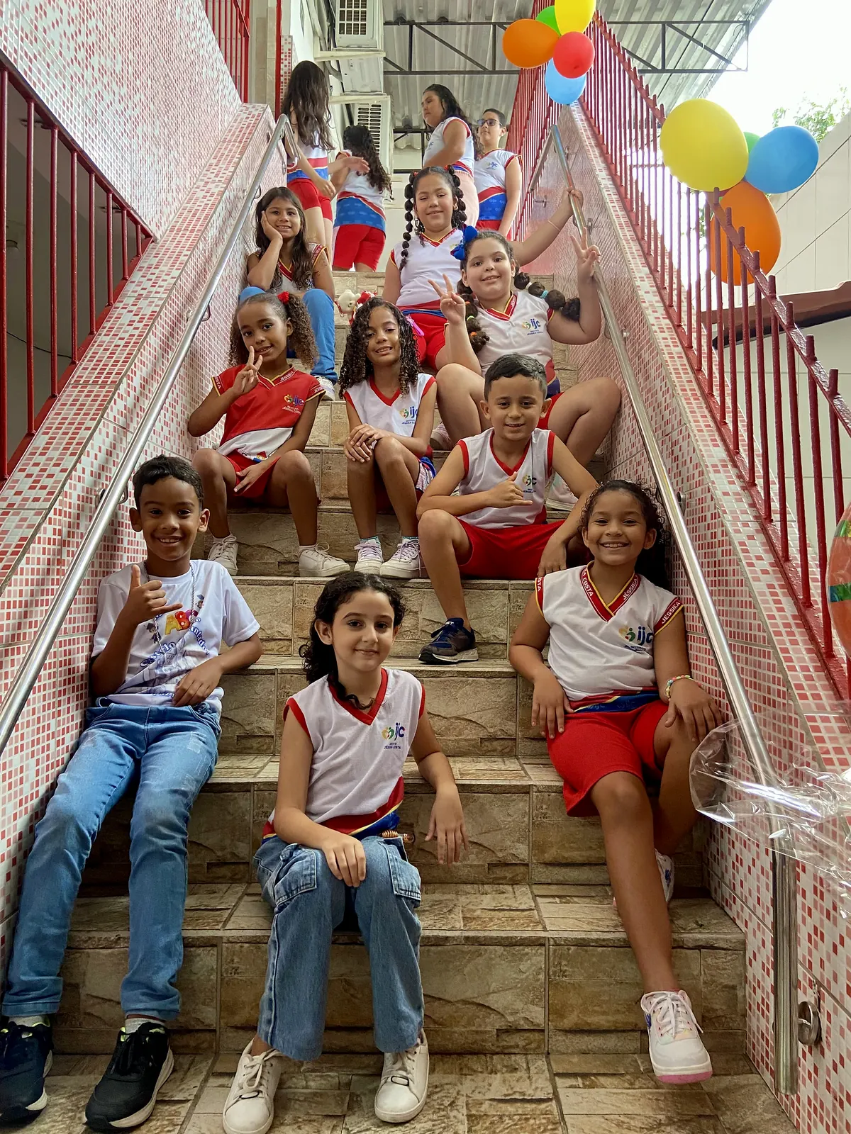 Grupo de estudantes reunidos na escada da escola.