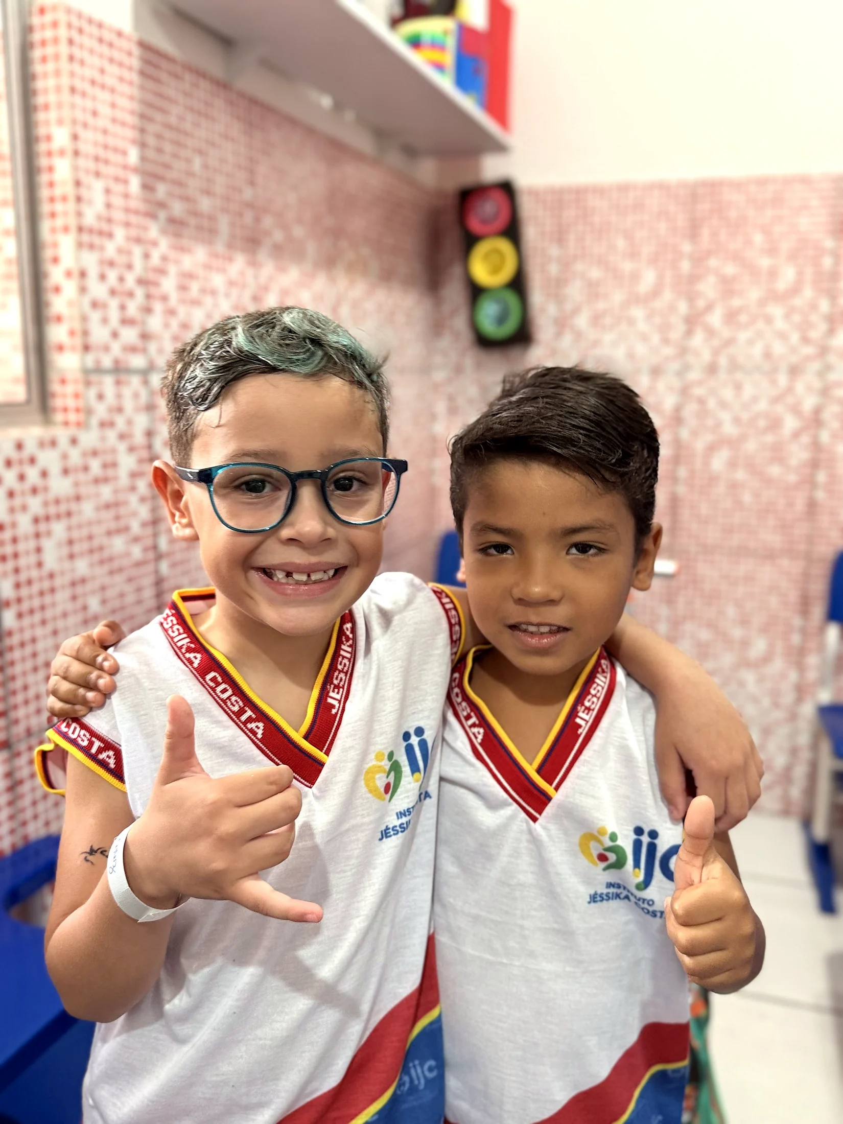 Dois estudantes sorrindo e abraçados.